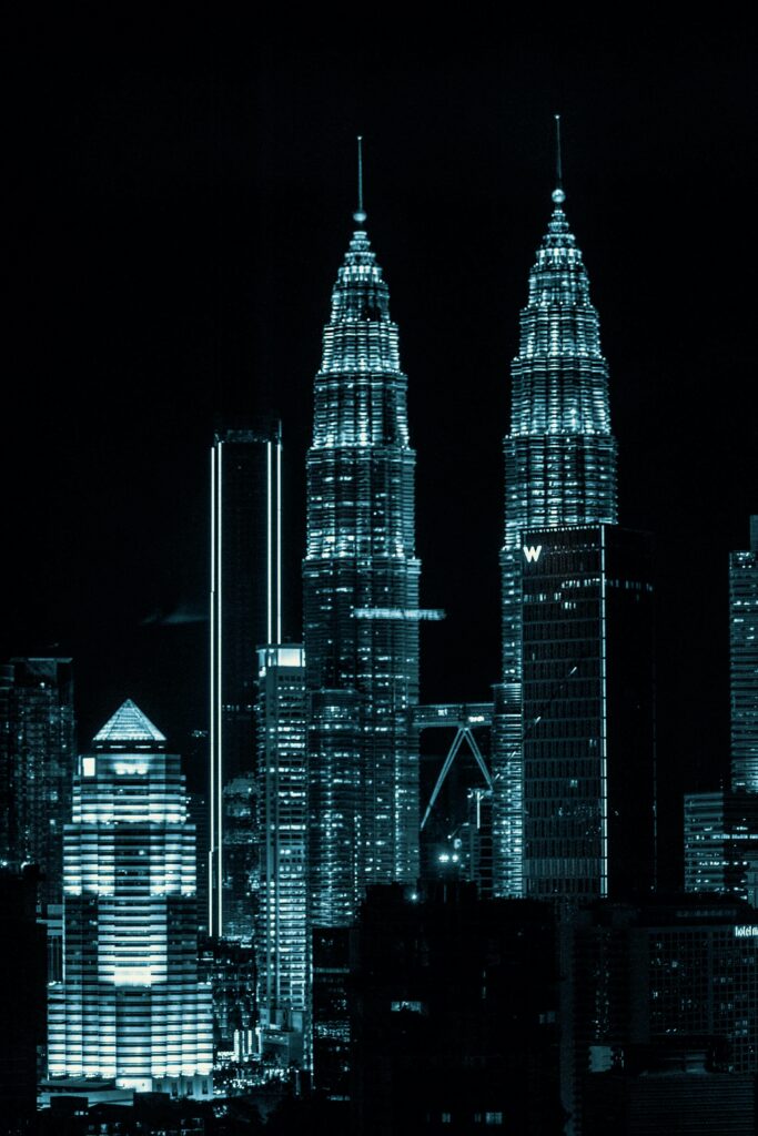 Dazzling night view of Kuala Lumpur cityscape showcasing the iconic Petronas Twin Towers.