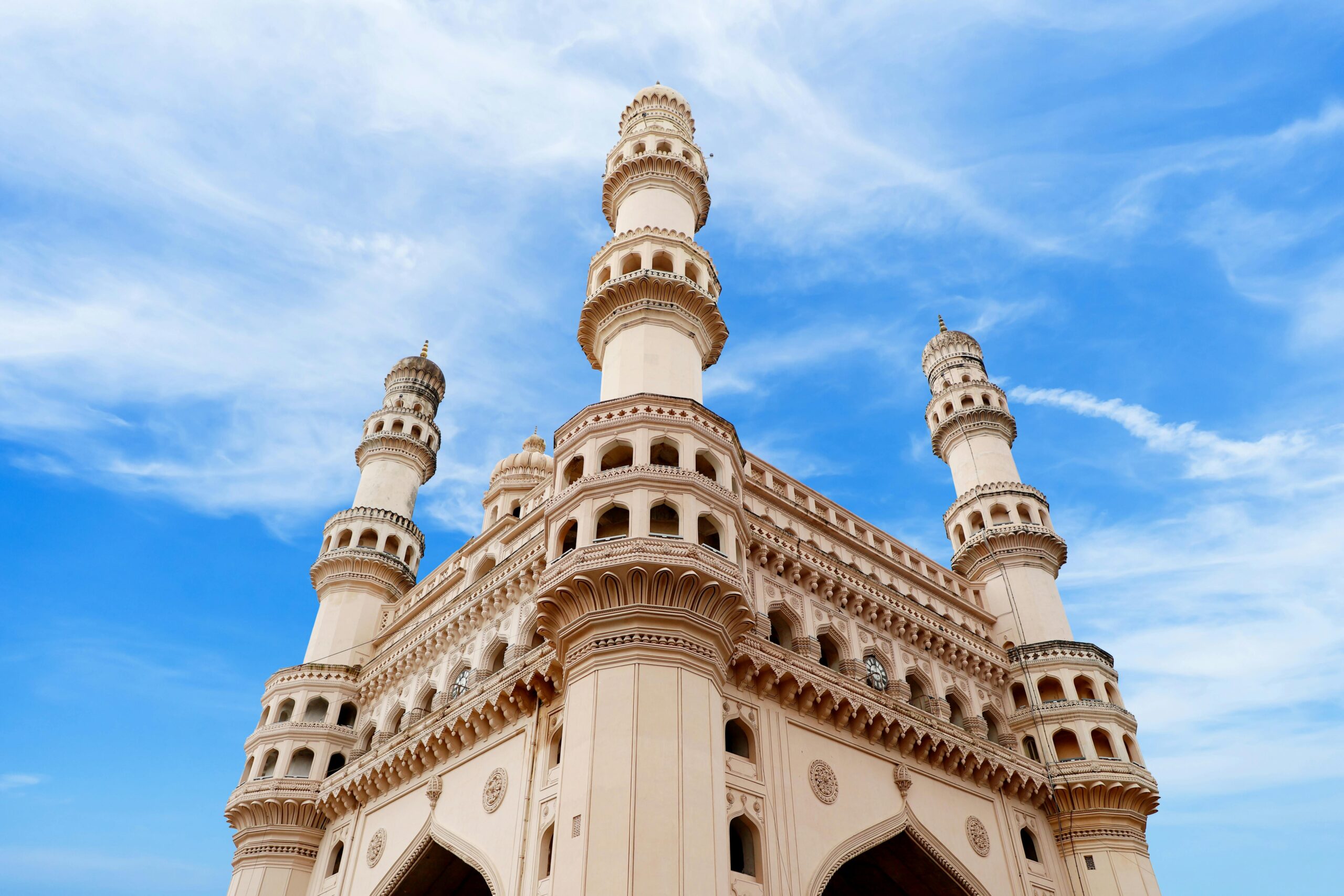 A stunning architectural shot of Charminar against a bright blue sky in Hyderabad, India.