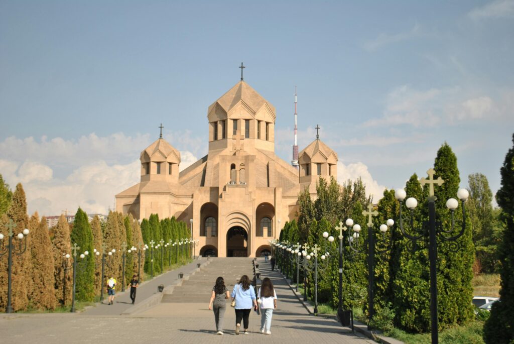 A group walks towards Holy Cross Cathedral, Yerevan, Armenia.