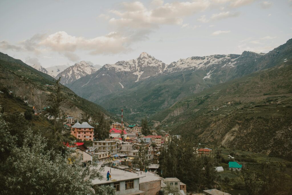 Picturesque village nestled in the Himalayan mountains of Manali, India, during a calm day.